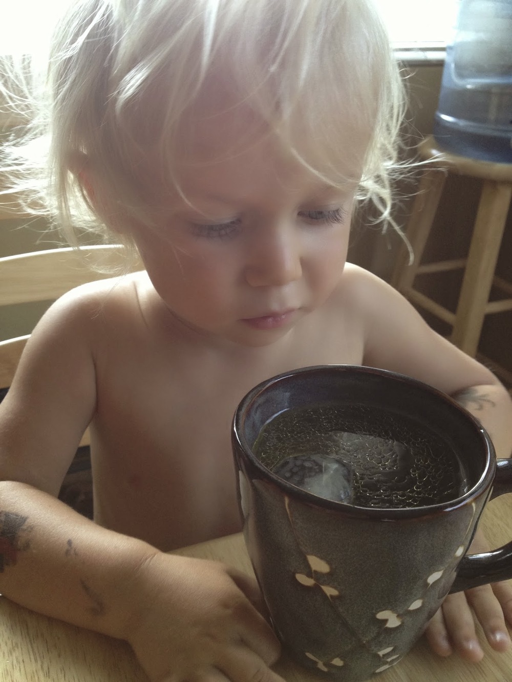 little boy sipping on a mug with broth 