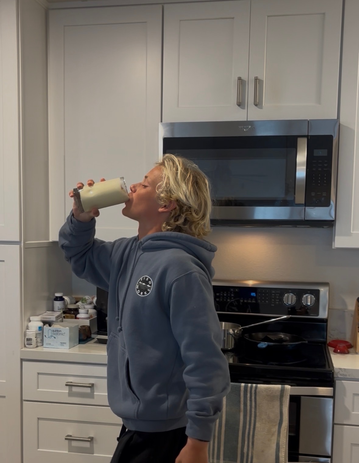 teenage boy drinking a smoothie in the kitchen