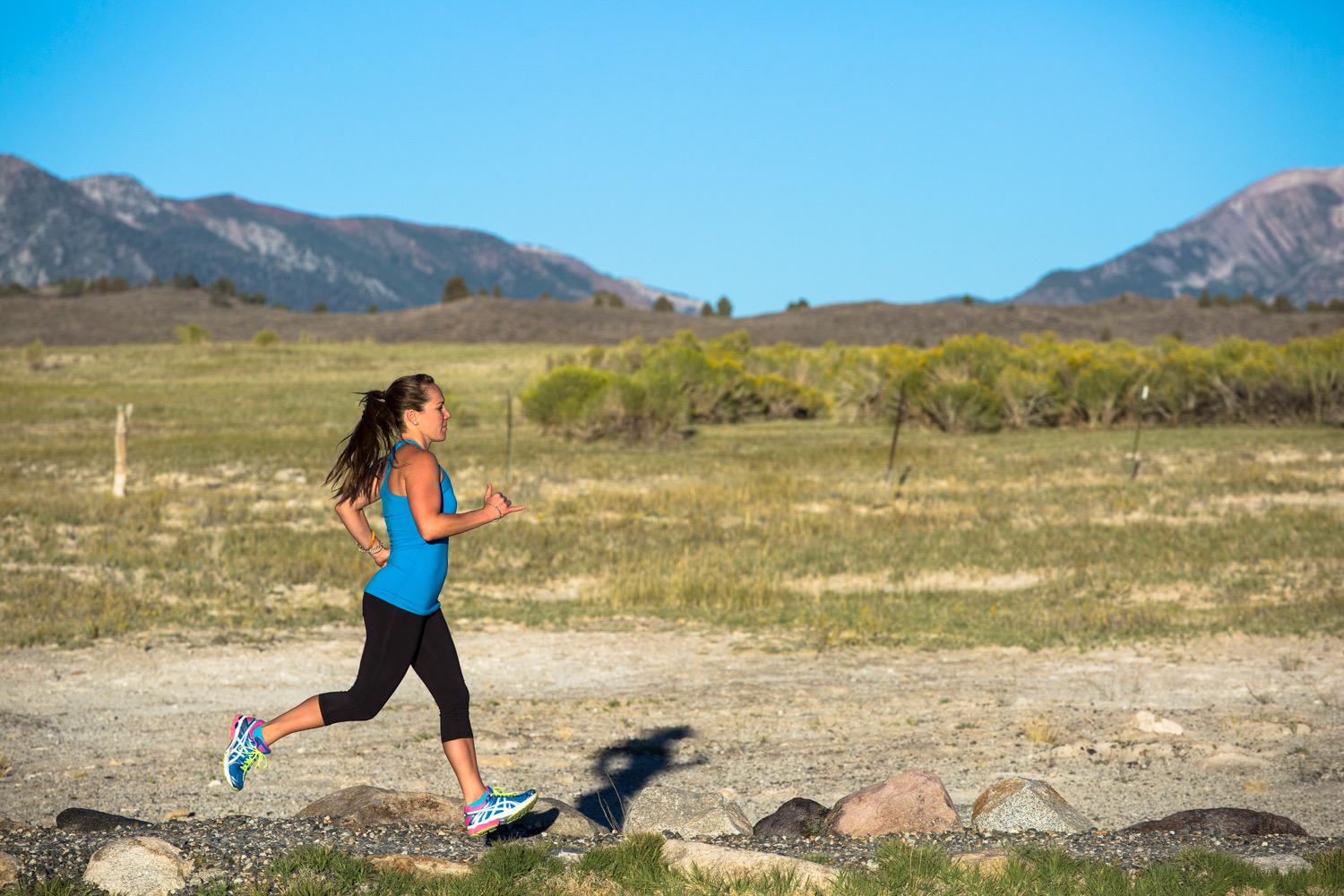 girl running with running outfit and tennis shoes and dessert behind her