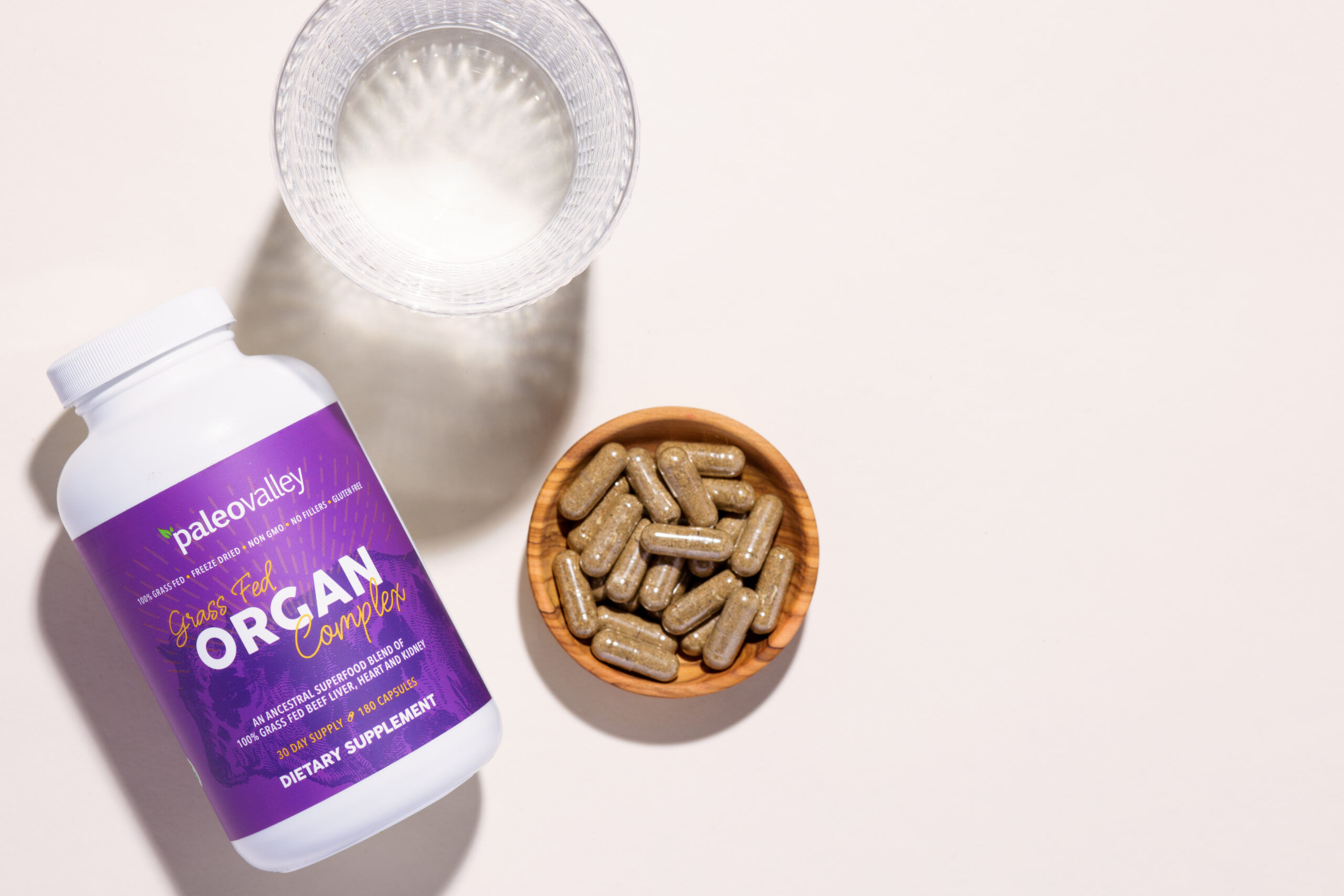 a bottle of paleo valley organ complex next to a glass of water 