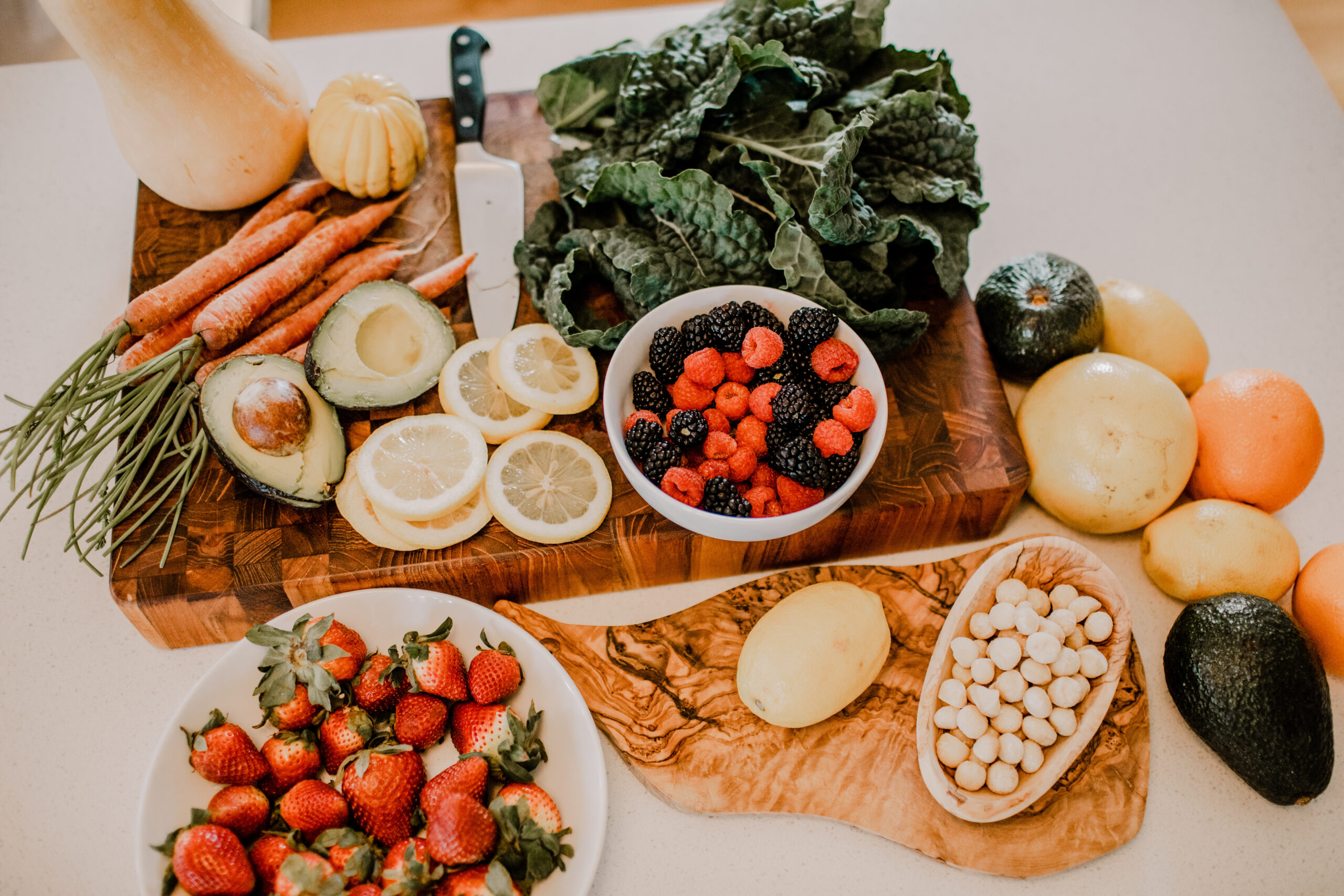 beautiful array of organic veggies, nuts, eggs and citrus on a cutting board