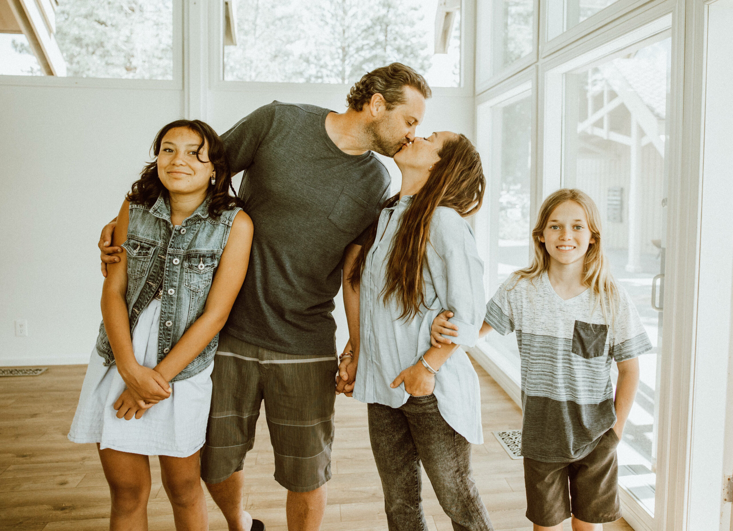 mom and dad kissing with daughter next to dad and son next to mom